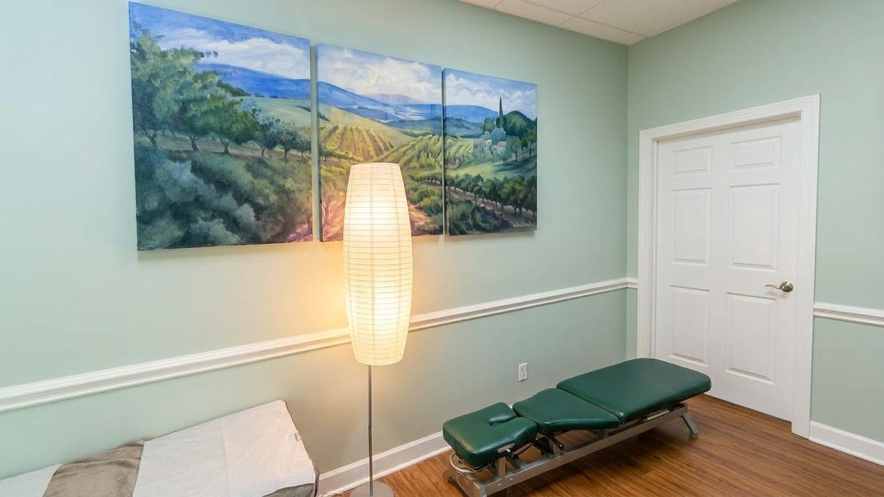 Quiet treatment room with a treatment table, a floor lamp and a landscape painting