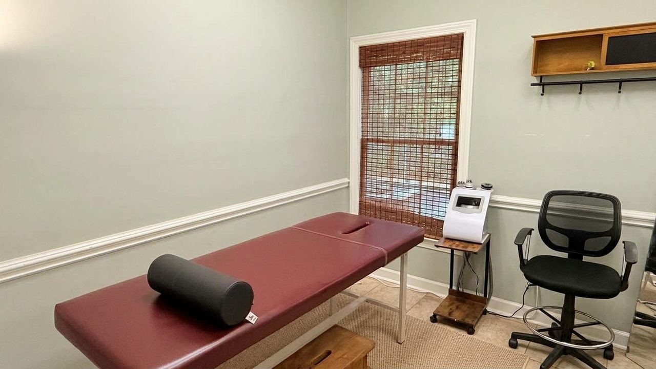 Treatment room with a padded table, a bolster and window blinds